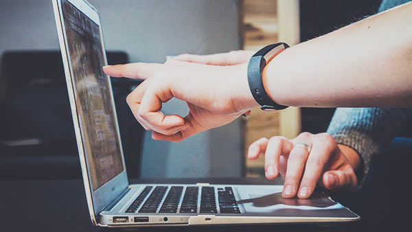 People using and pointing at laptop screen